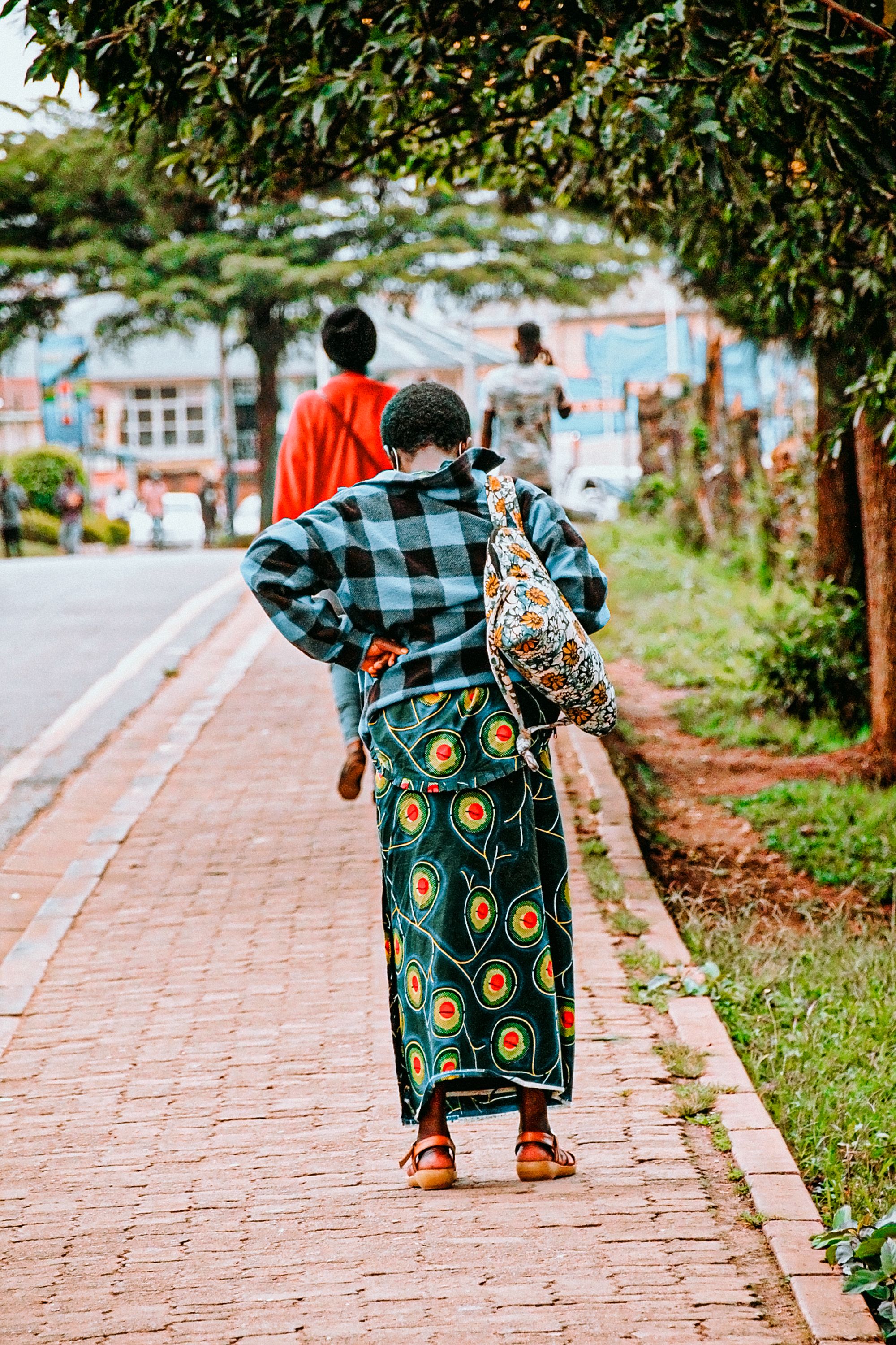 Mulher vista de costas, andando com as mãos protegidas atrás do corpo