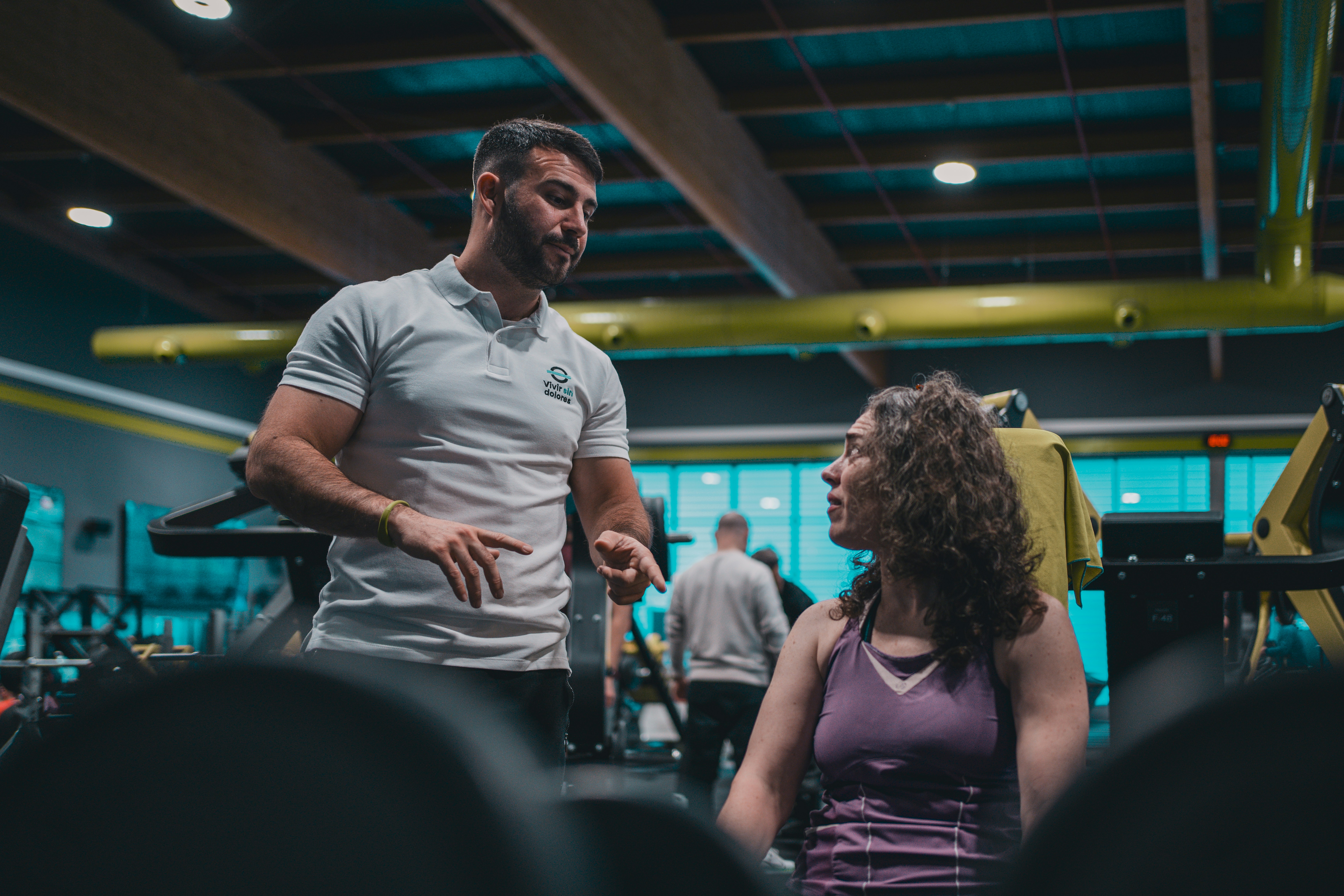 Personal trainer conversando com uma cliente em uma academia